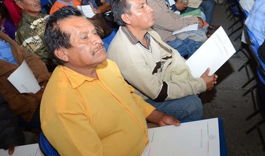 Ejidatarios con documentos que acreditan su propiedad rural.
