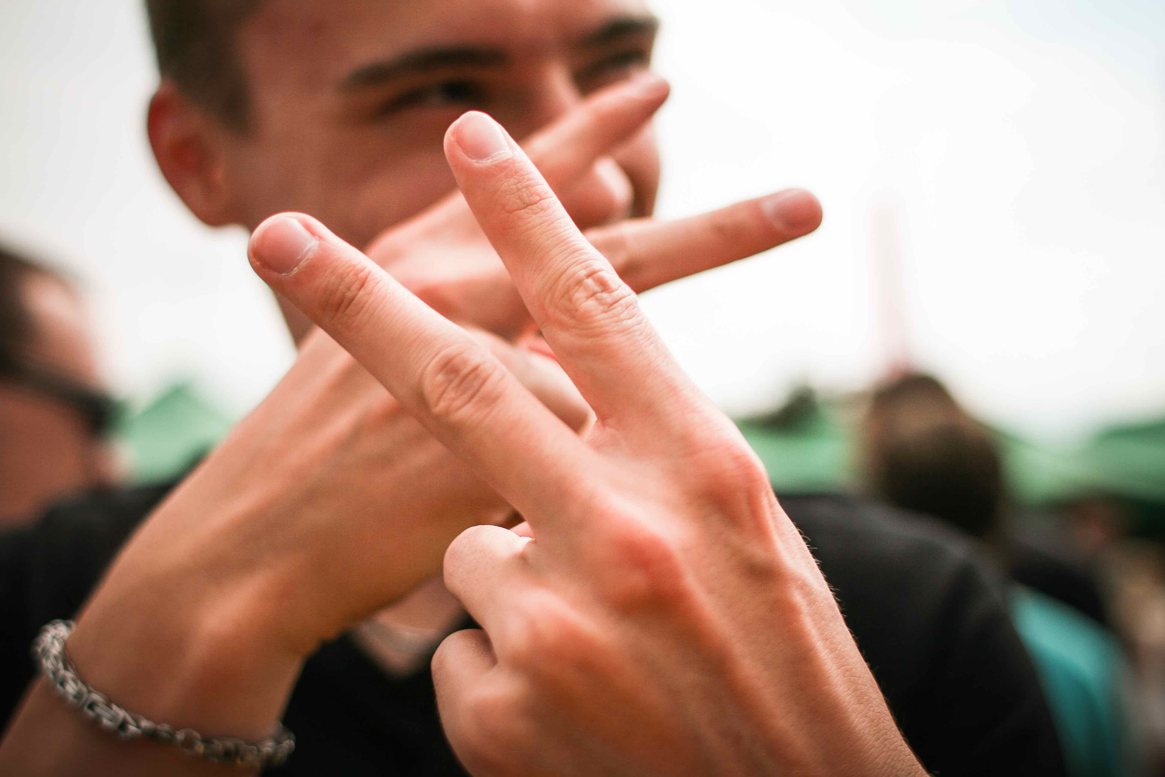 Imagen de un joven que hace la señal de tag con las manos.