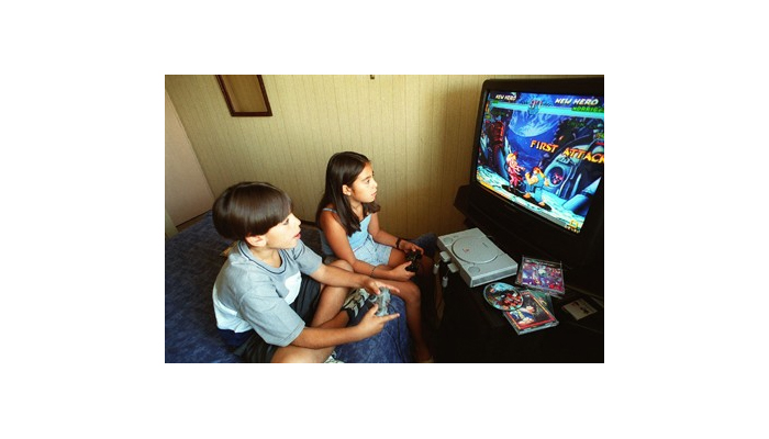 Niña y niño usan videojuego.