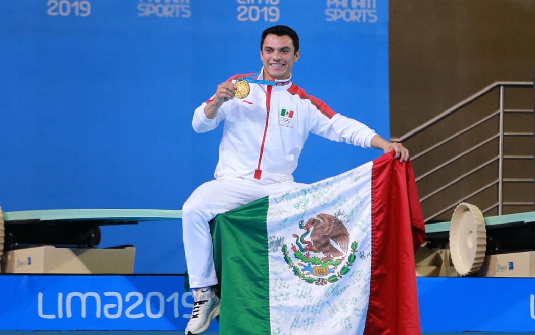 Yahel Castillo celebra con la bandera de México tras ganar la medalla de oro en clavados sincronizados en Lima 2019.
