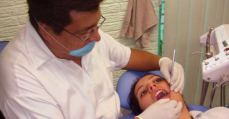 Dentista atendiendo a una mujer joven.