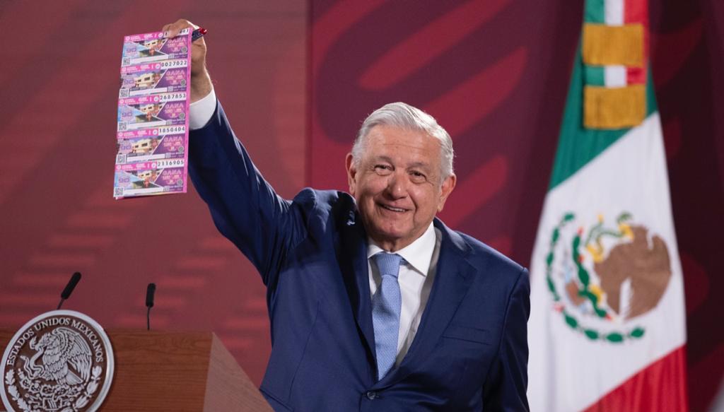 Fotografía del Presidente Andrés Manuel López Obrador con una serie de billetes del Gran Sorteo Especial 260 en la mano derecha