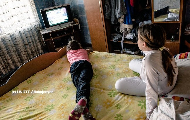 Dos niñas ven televisión en su cuarto.