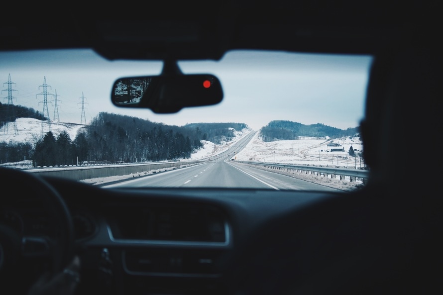 Fotografía desde el panorámico de un automóvil de una vía en zona con nieve