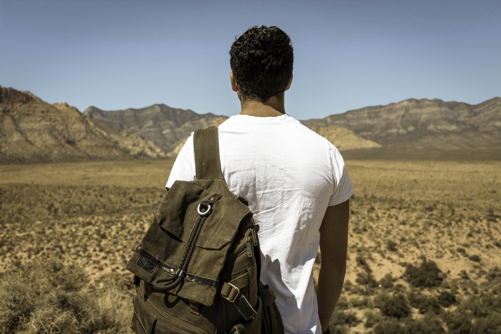 Fotografía de un joven con una mochila visto de espaldas.