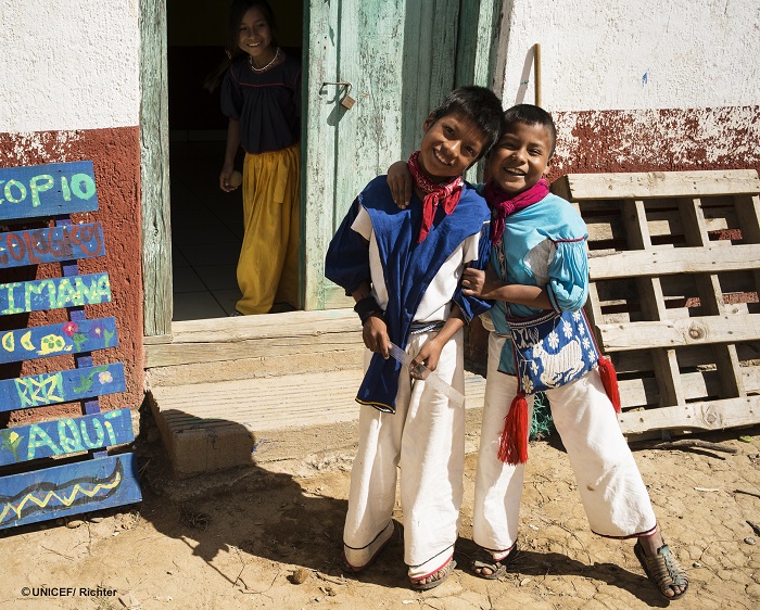Una niña en la puerta y dos niños abrazados, de la comunidad indígena Wixárica / Huichol, de Nayarit, México.