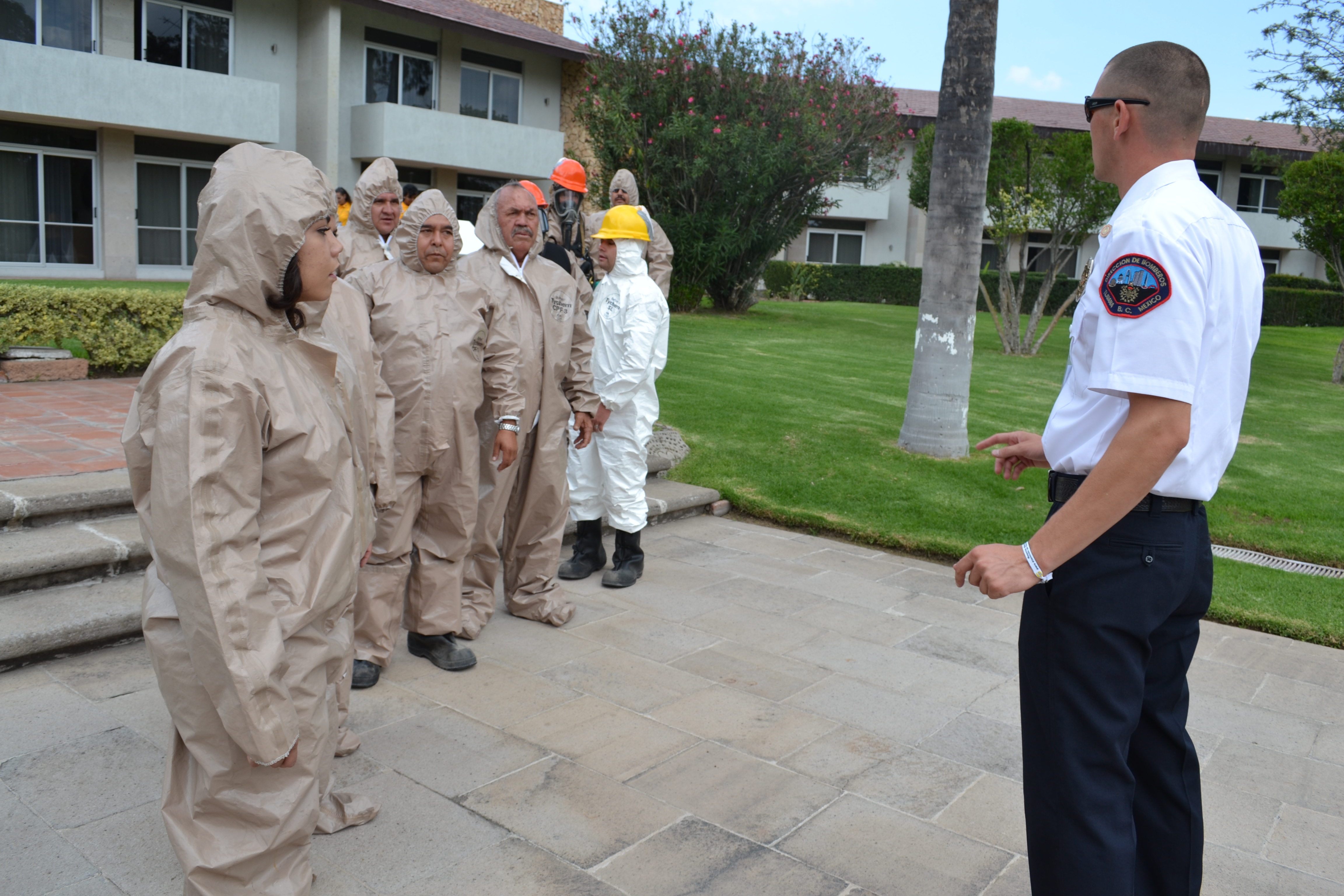 Personal de protección civil se encuentra en formación con uniformes de manejos de sustancias químicas, como parte de la capacitación que reciben de Bomberos de Tijuana y la Unidad Estatal de Protección Civil de Baja California