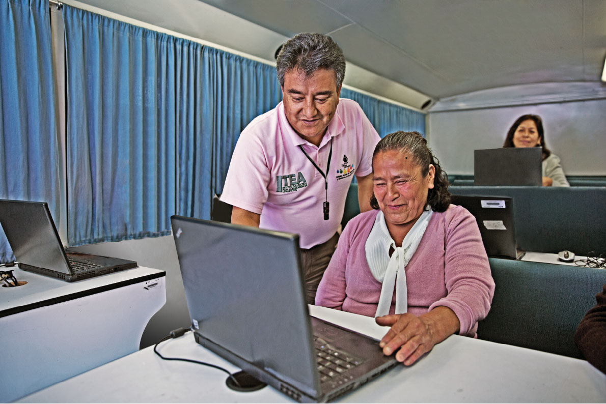 Mujer adulta mayor presentando examen en línea con ayuda de un instructor del ITEA