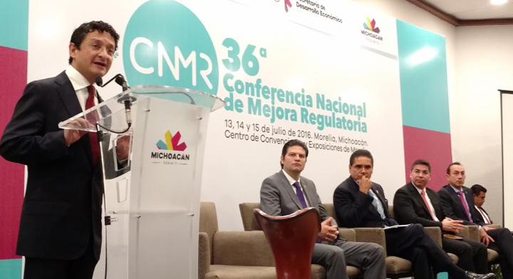 Secretario Virgilio Andrade dando mensaje en su participación en la 36 Conferencia de Mejora Regulatoria, al fondo 5 hombres más sentados en el panel