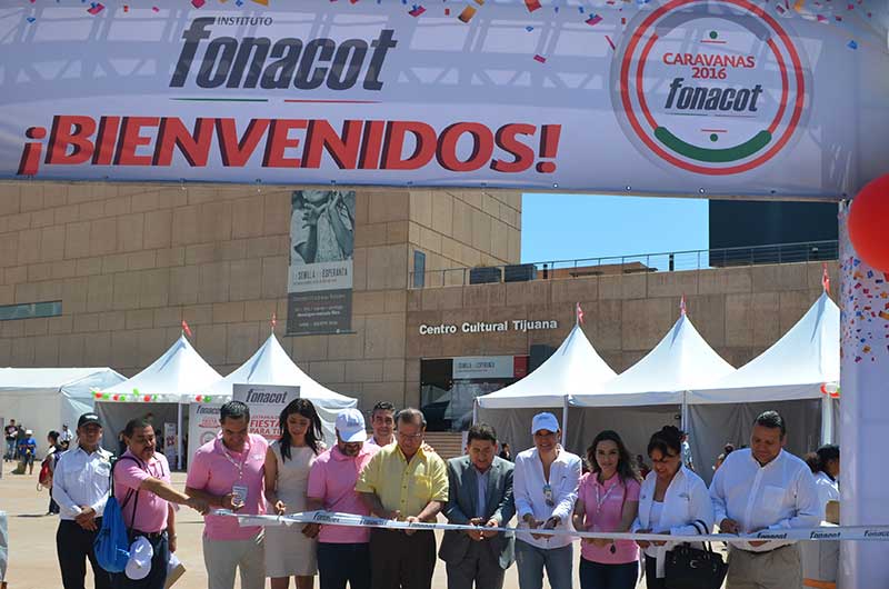 Nueve personas cortando el listón de inauguración de caravana FONACOT Tijuana