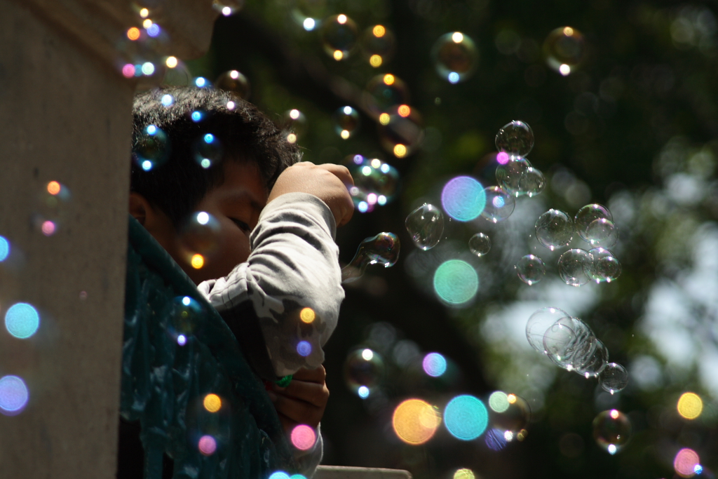 Imagen de un niño jugando a hacer burbujas de jabón.