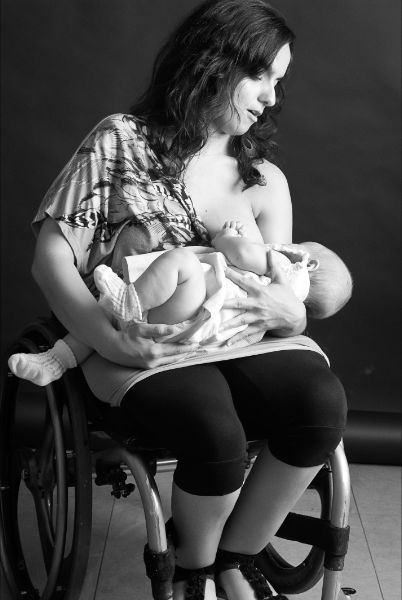 Mujer usuaria de silla de ruedas amamantando a su bebé