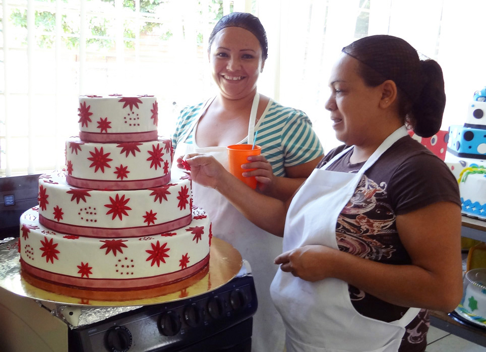Dos mujeres decorando un pastel.