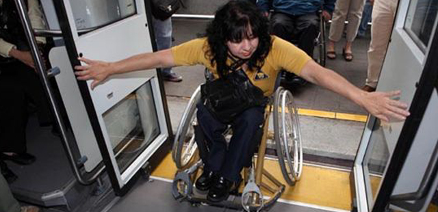 Mujer en silla de ruedas subiendo al  transporte público