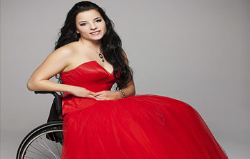 Mujer usuaria de silla de ruedas con vestido rojo