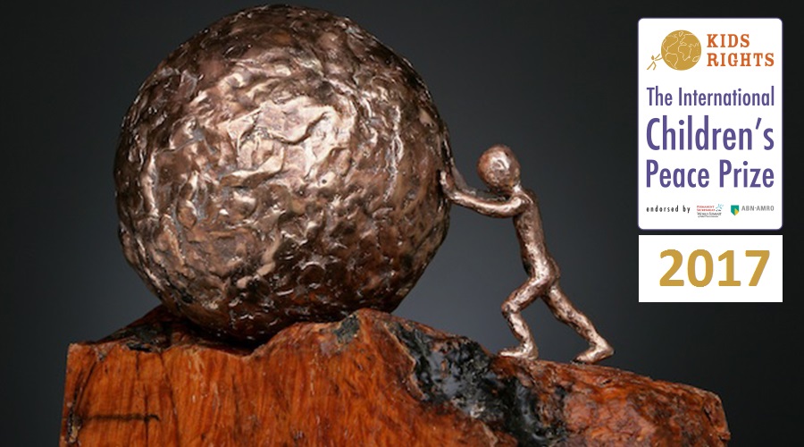 Galardón con base de madera. Un niño empuja un globo terráqueo. Símbolo del Premio Internacional.