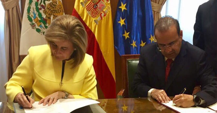 Dos personas, un hombre y una mujer firmando un documento.