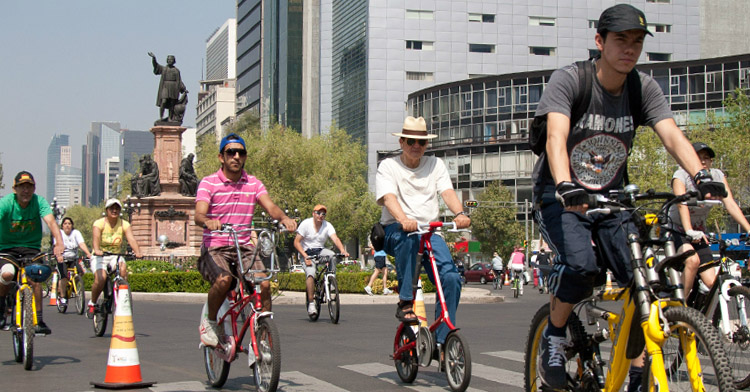 Grupo de personas circulando en bicicleta sobre avenida de la Ciudad de México.
