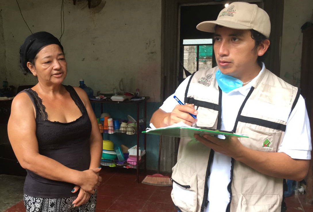 Mujer siendo atendida por brigadista de SEDATU, quien toma sus datos sobre afectaciones en vivienda.