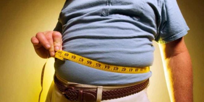 Persona con obesidad se mide con cinta métrica