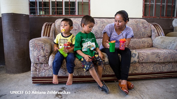 Dos niños sentados en un sofá de un centro para refugiados privado, en México