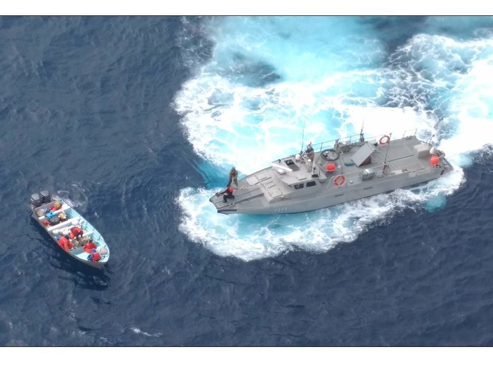 Toma aérea picada de vehículo marino oficial interceptando a una lancha para corroborar su legalidad.