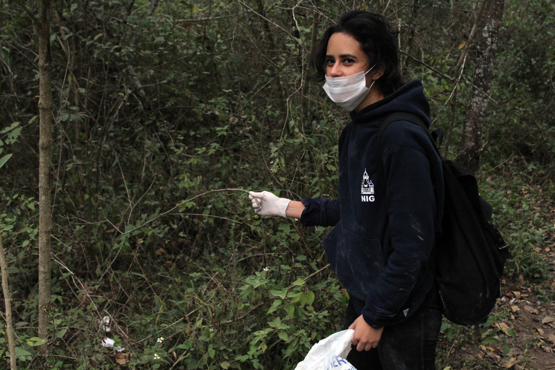 Mujer joven limpiando el bosque
