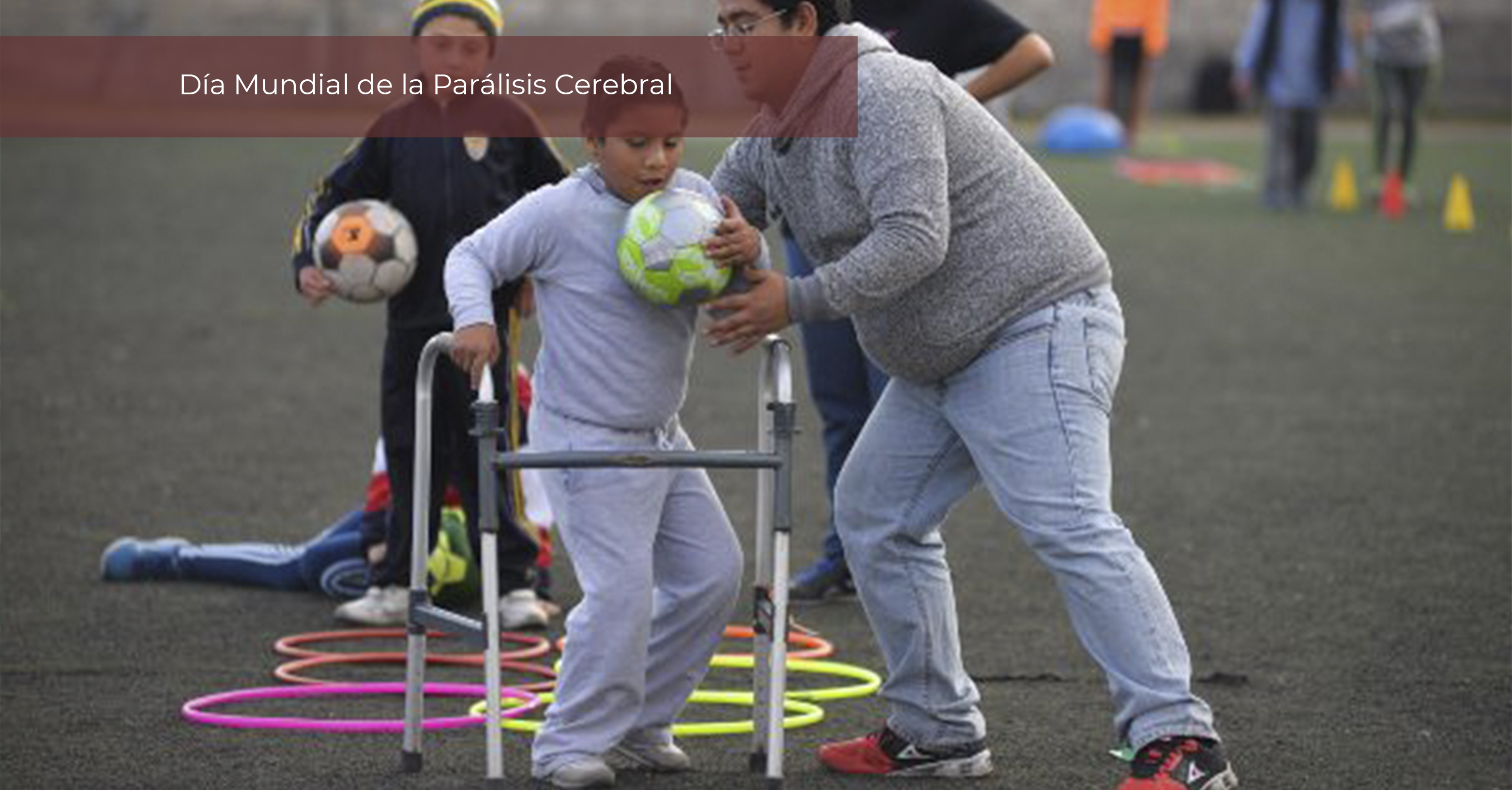 Niño con parálisis cerebral con andadera juega en un campo con su profesor de educación física y compañeros.