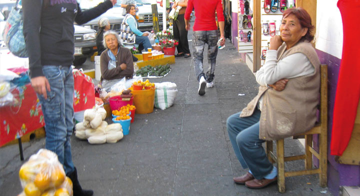 Mujeres adultas vendiendo en la calle frutas, aguadates, miel