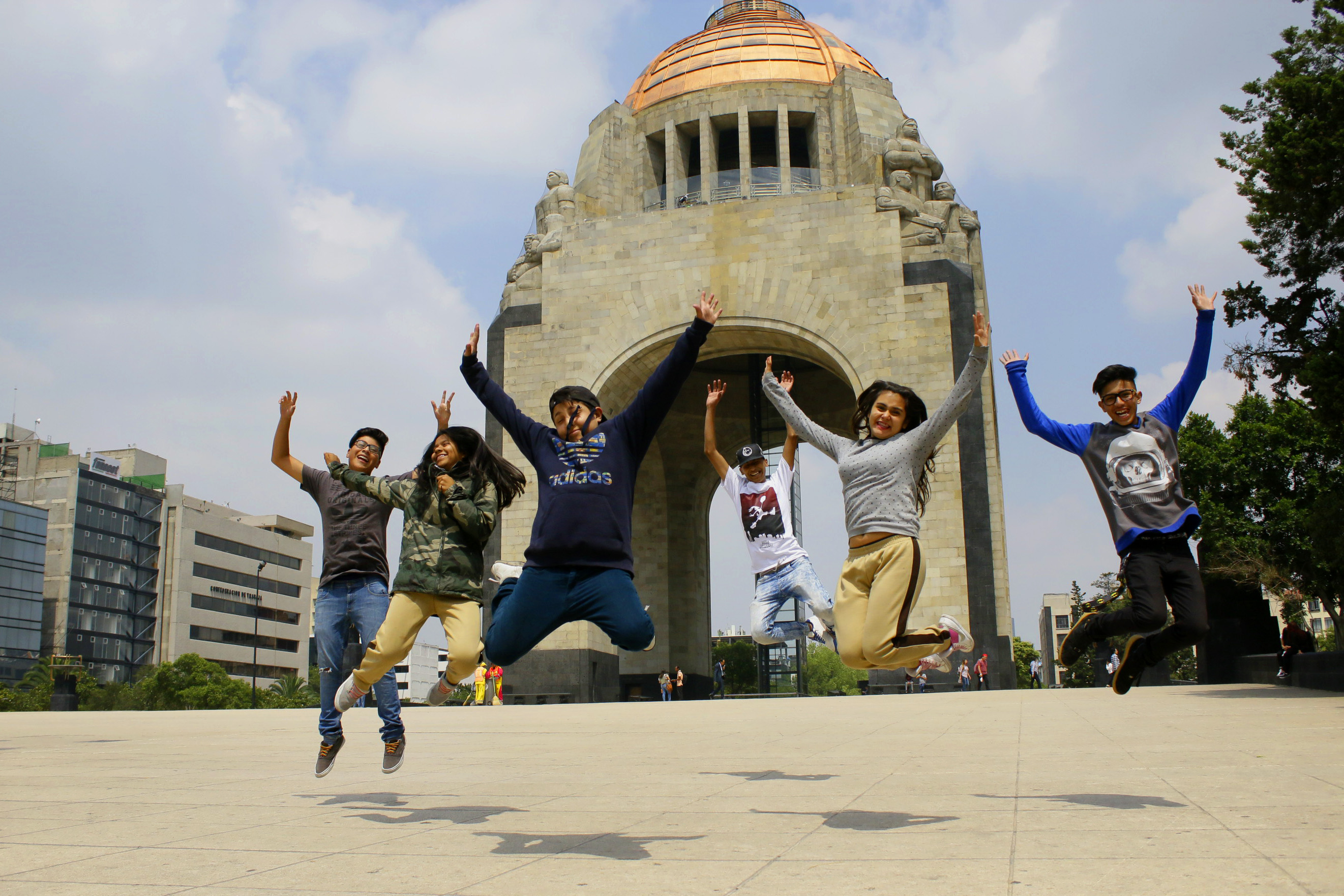 Jóvenes brincando frente al monumento a la Revolución