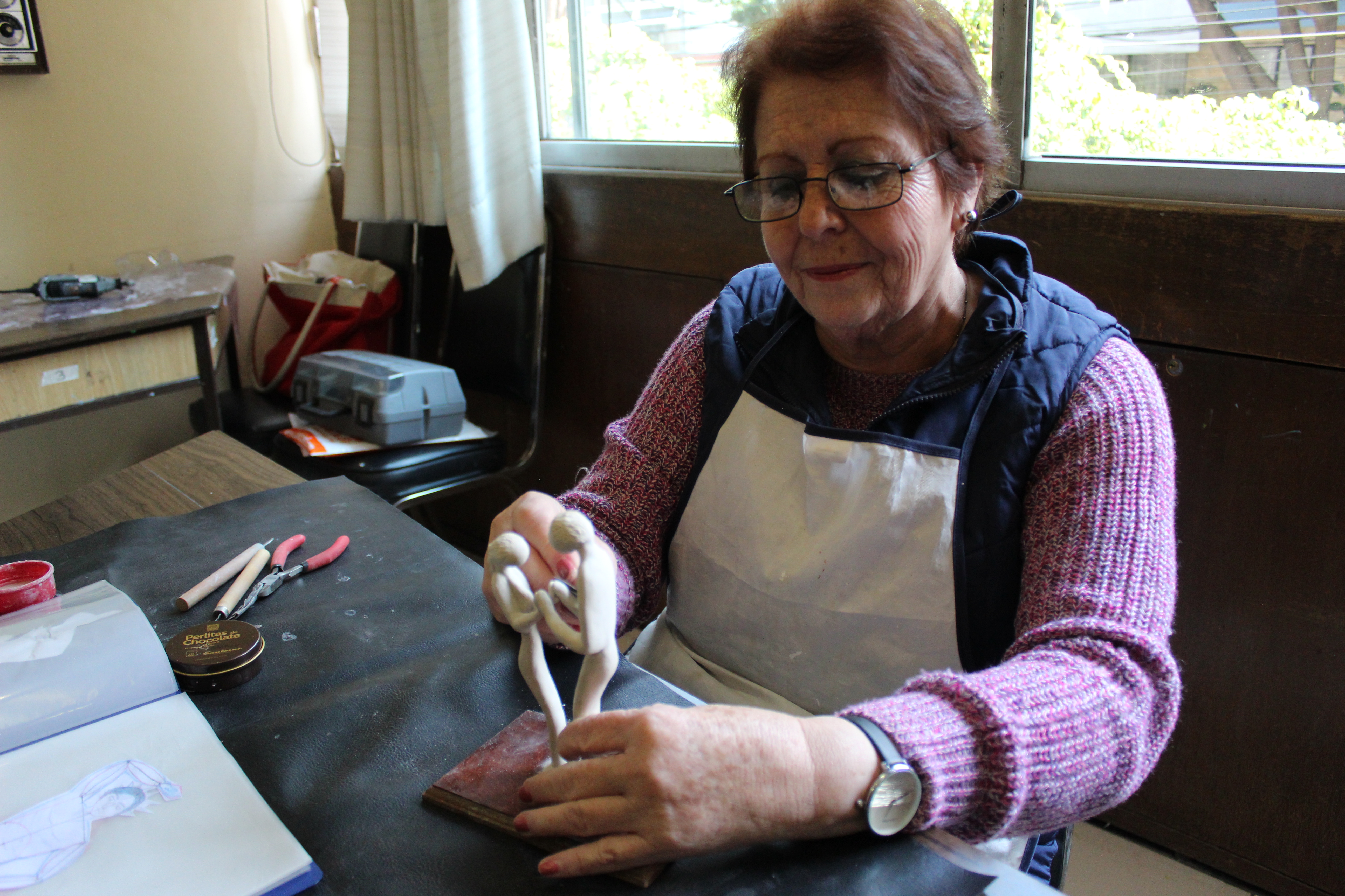 Adulta mayor haciendo una pieza de plastilina époxica en el Centro Cultural San Francisco.  