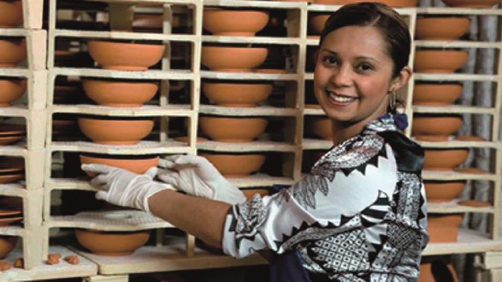 Mujer acomodando platos de barro en stock