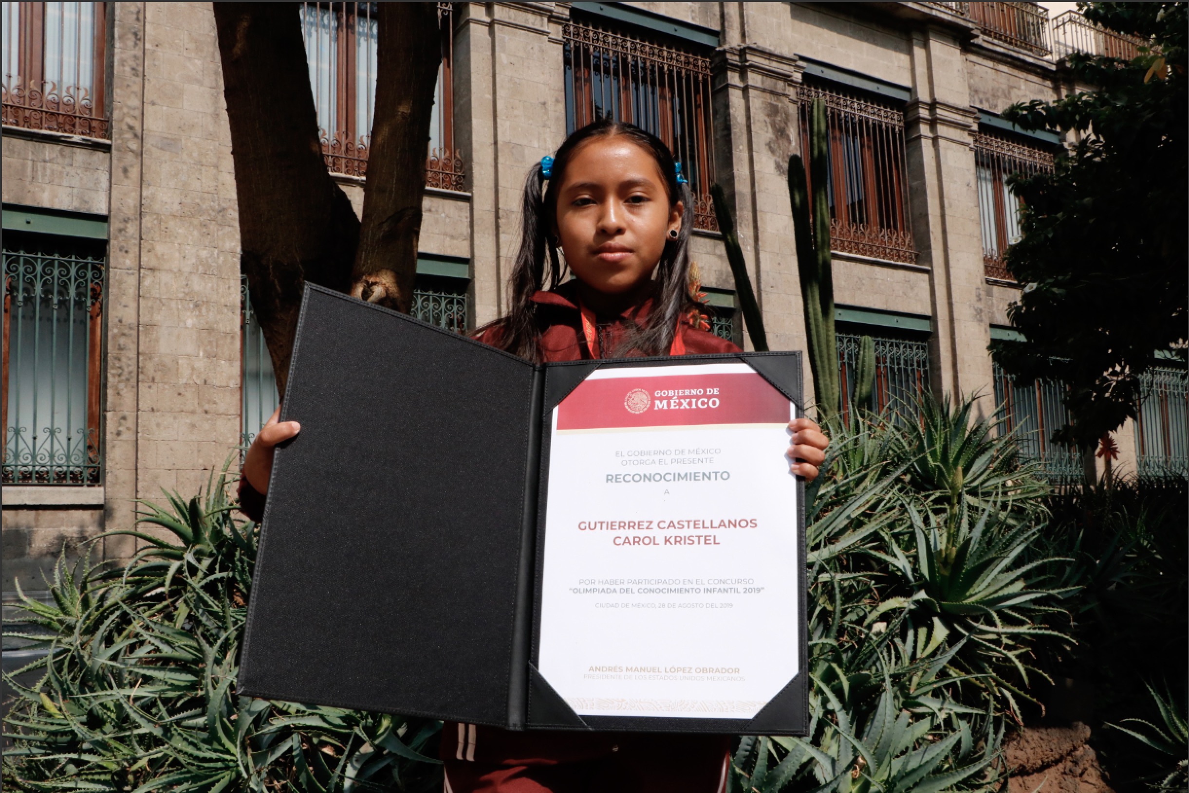 Carol Kristel Gutiérrez Castellanos, alumna del Conafe, recibe reconocimiento en manos del presidente Andrés Manuel López Obrador y de su esposa Beatriz Gutiérrez Müller.