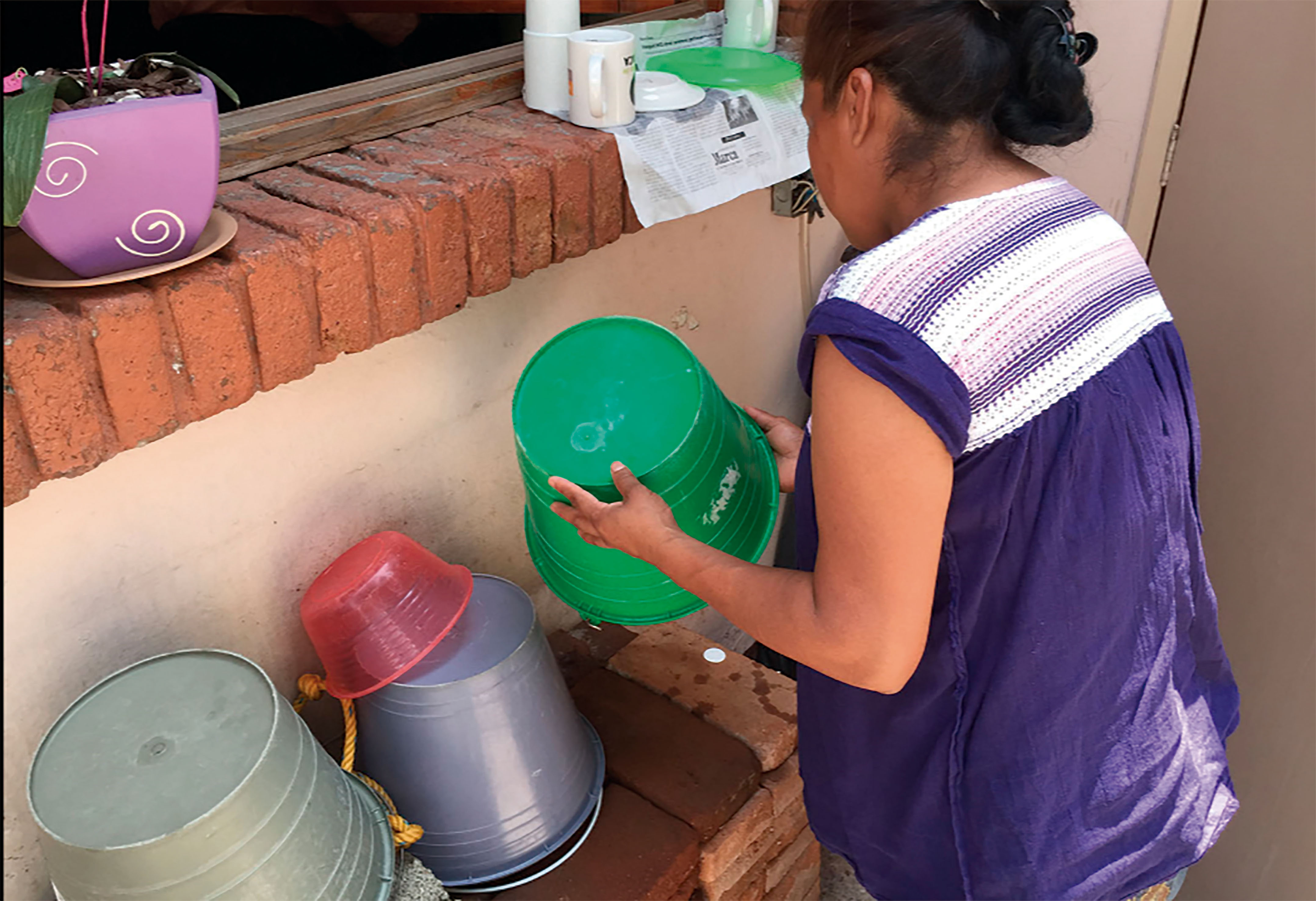 Mujer lavando cubeta.