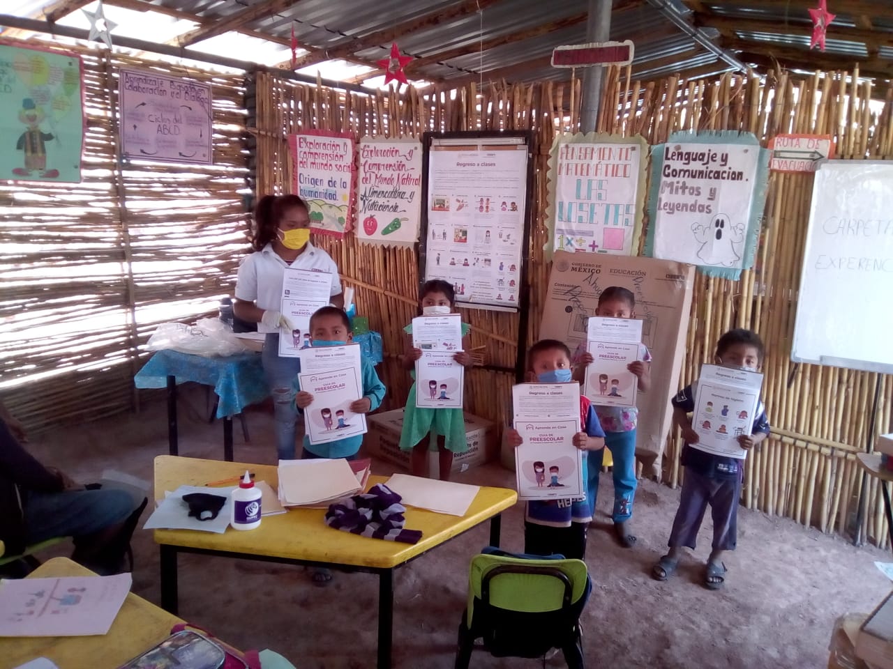 Niños y maestra mostrando sus materiales.
