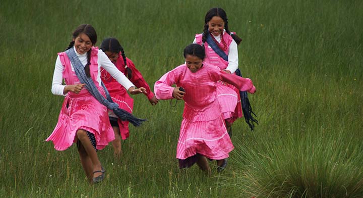 Jóvenes mujeres sonriendo y corriendo en parcela del Estado de México