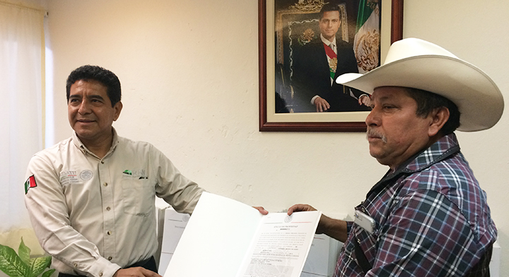 Delegado del RAN, Juan Miguel Deras Maldonado, entregando a José Bernardino Lopez Contreras, comisariado ejidal de Alfredo V. Bonfil