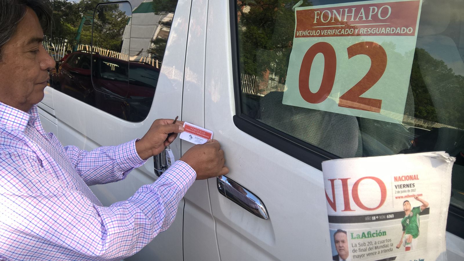 Personal de una delegación estatal de FONHAPO pone sellos de “Vehículo Verificado y Resguardado”.