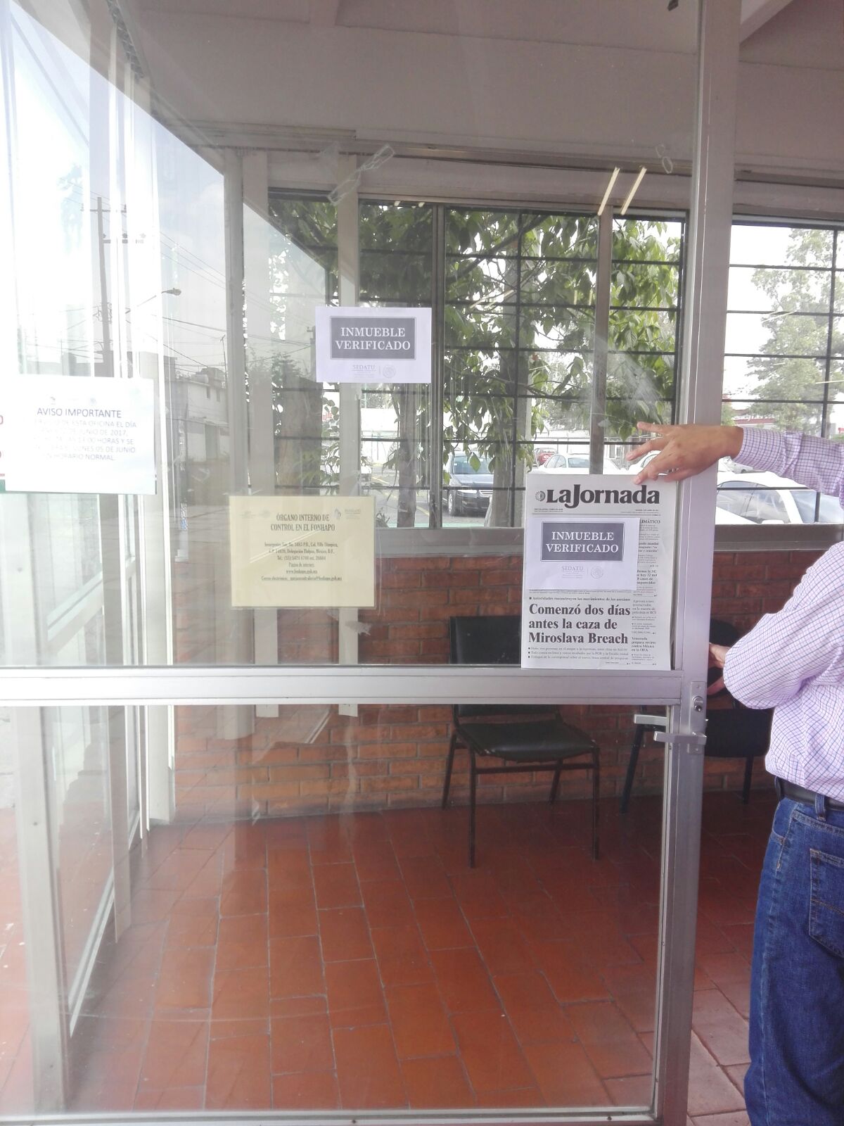 Personal de SEDATU instala sellos de “Inmueble Verificado” en la puerta de entrada a sus oficinas.