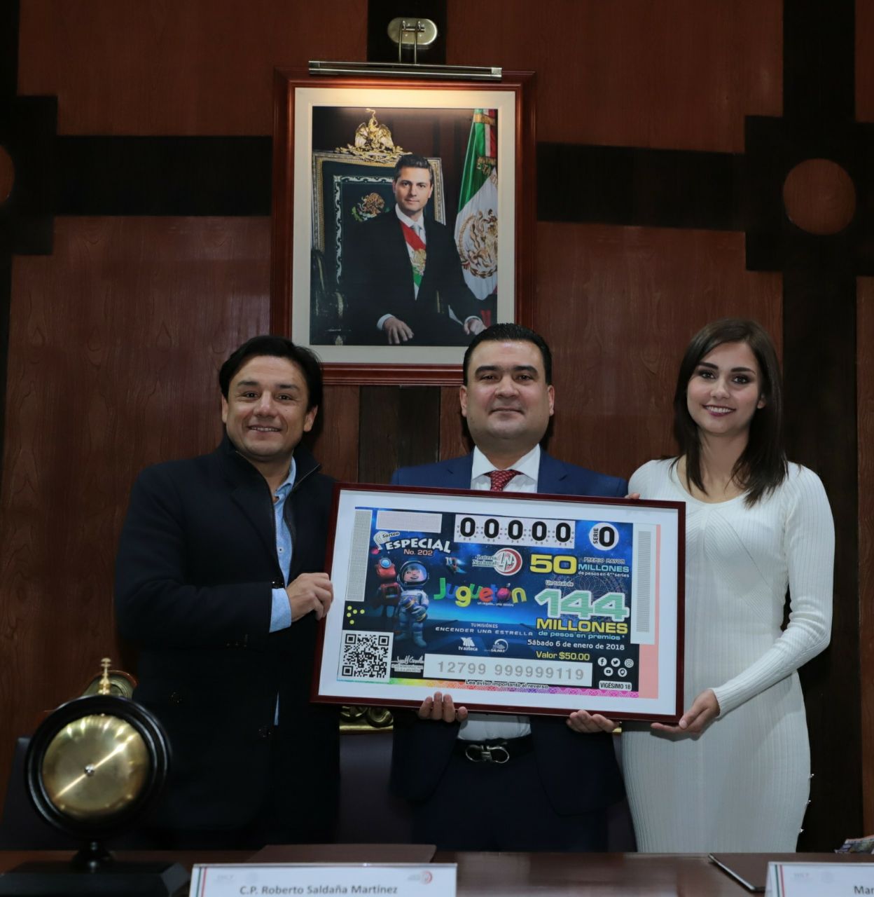 Fotografía mostrando el billete de Juguetón 2018 acompañado a Roberto Saldaña los conductores Esteban Macías y Maríana Iparrea.