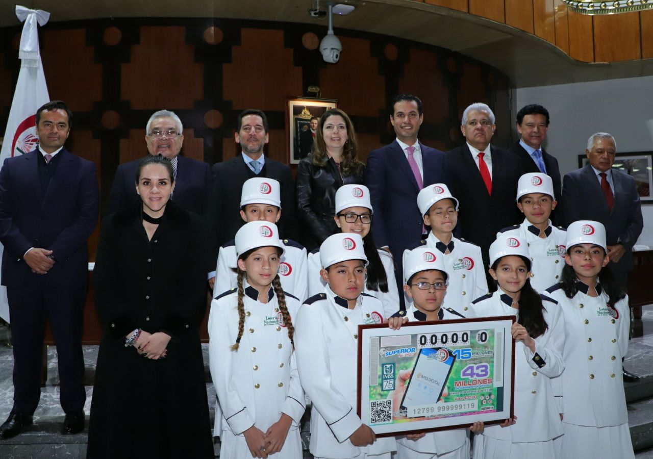 Fotografía con autoridades que presiden el evento junto a las y los niños gritones de Lotería Nacional. 