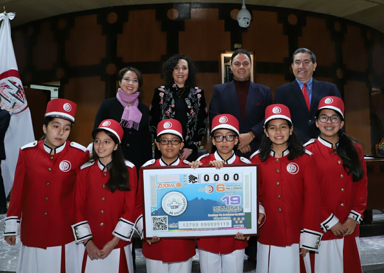 Fotografía de los miembros que encabezaron el Sorteo Zodiaco acompañados de las niñas y niños gritones de la Lotería Nacional  