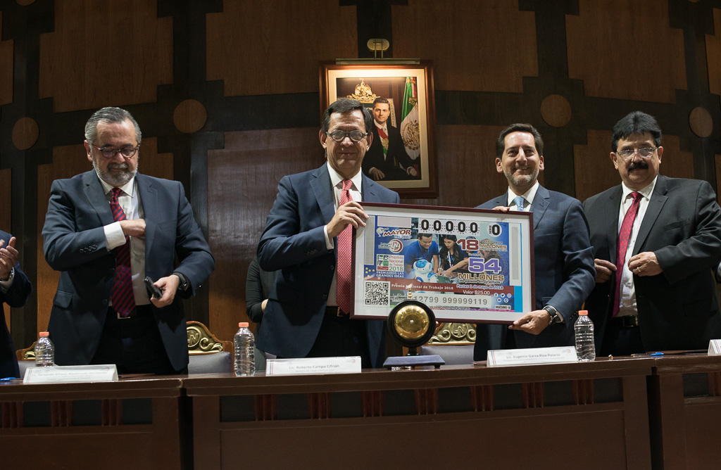 El Titular de la STPS Roberto Campa sosteniendo el billete de Lotería alusivo al Premio Nacional de Trabajo 2018