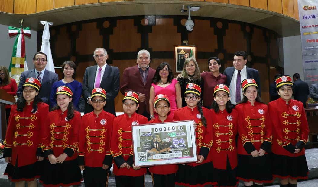 Fotografía de autoridades que encabezaron el sorteo acompañados de las niñas y niños gritones de la Lotería Nacional.