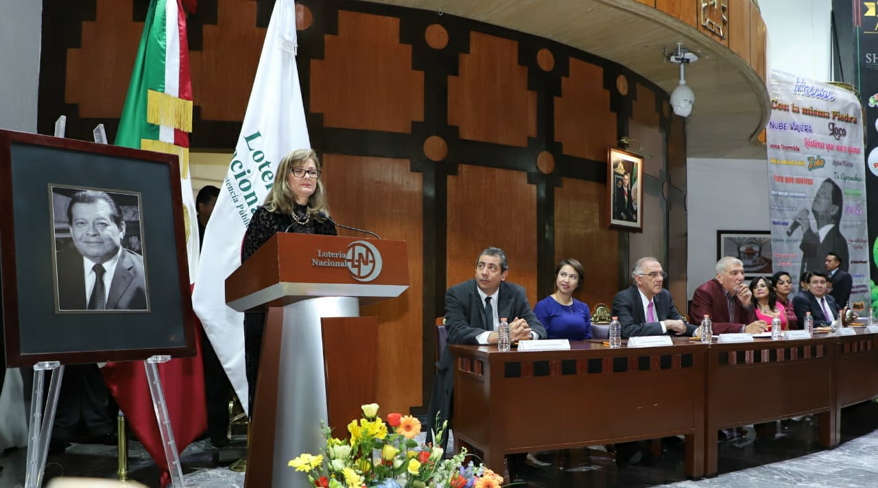Fotografía de Marcia Cortés Corral viuda del Jorge Macías Gómez dando palabras de agradecimiento a Lotería Nacional 