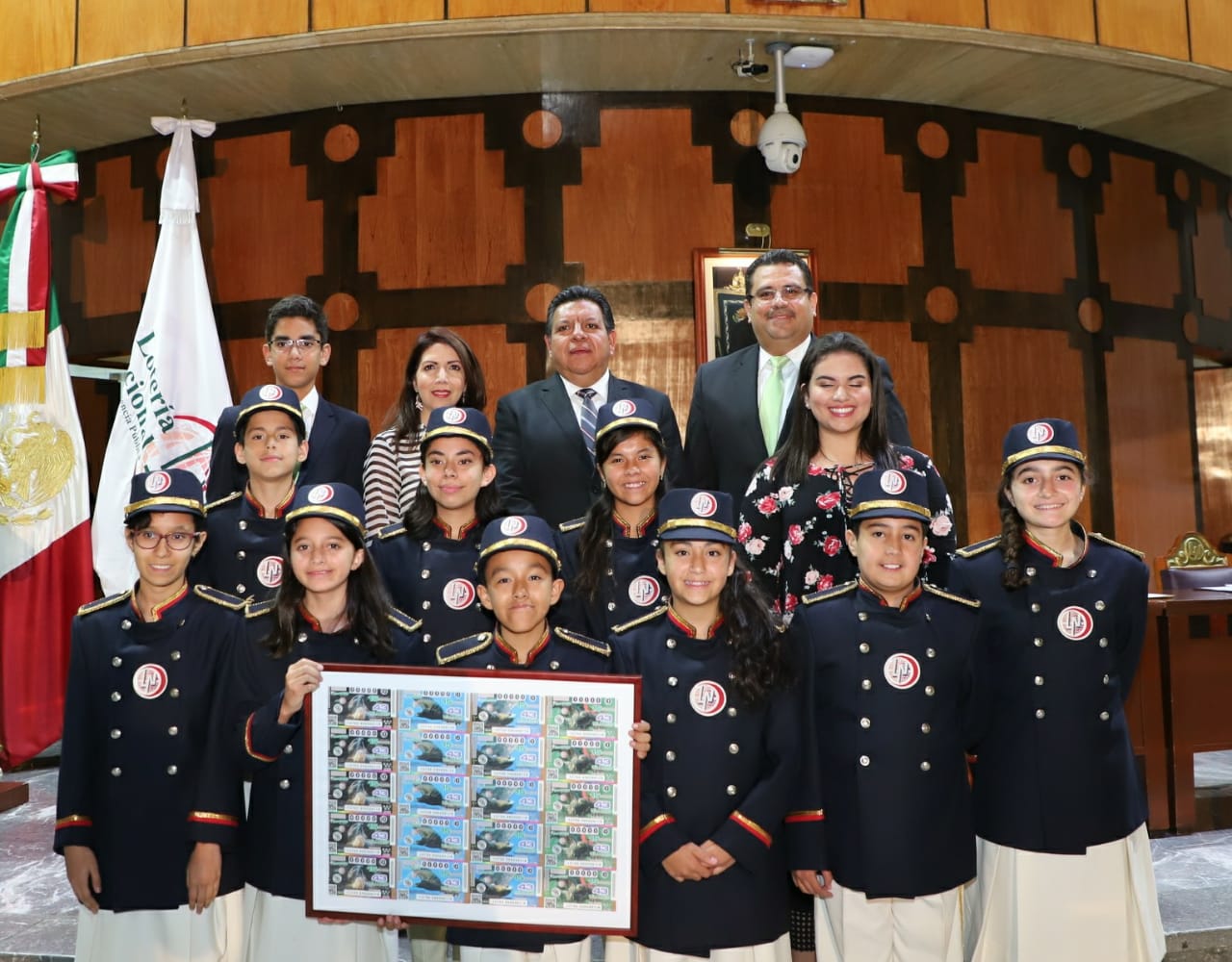 Fotografía de las autoridades que encabezaron el sorteo acompañados de las niñas y niños gritones de la Lotería Nacional.