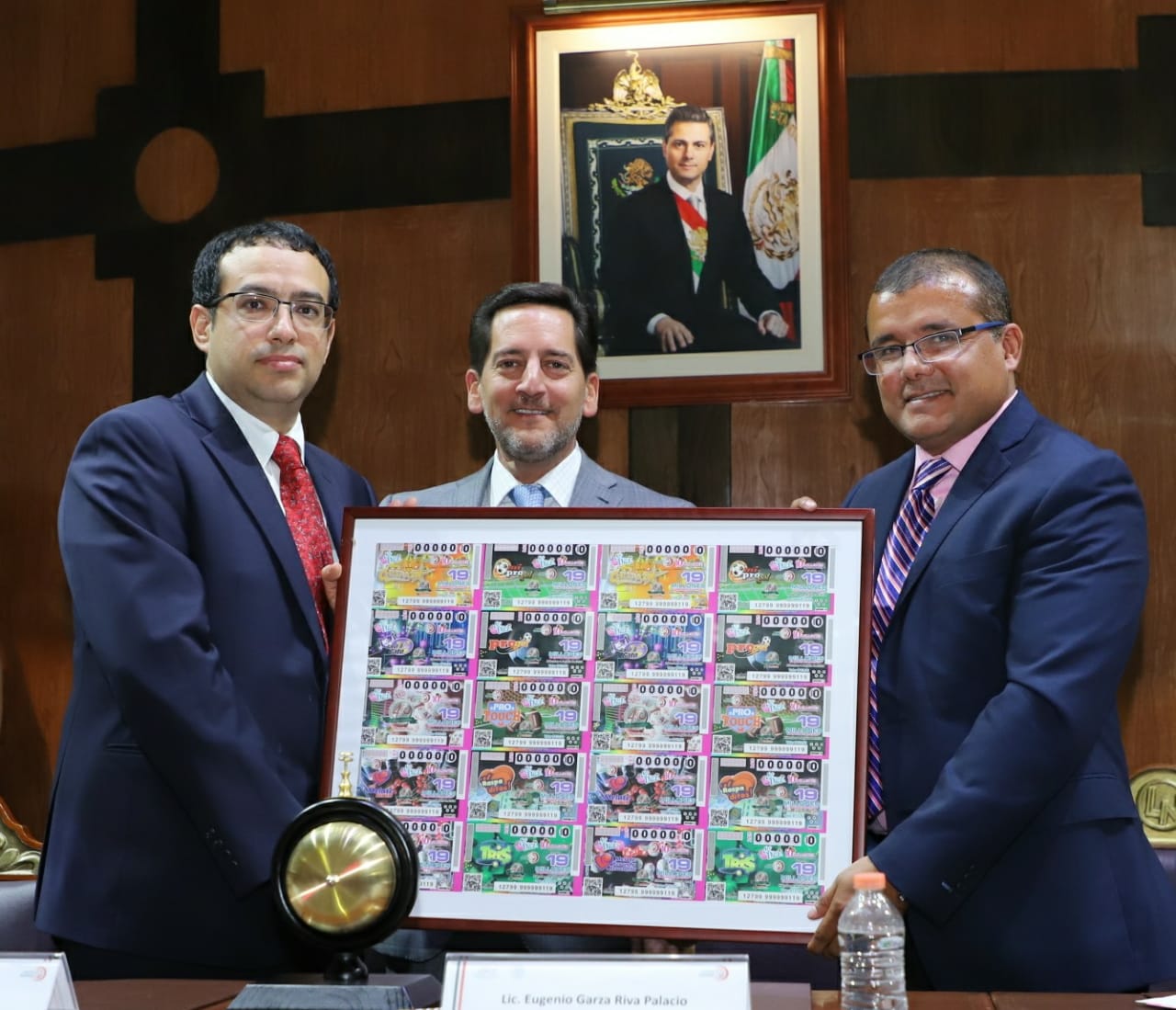 Autoridades de Pronósticos y Lotería Nacional sosteniendo el cuadro conmemorativo al billete electrónico del 40 aniversario de Pronósticos.