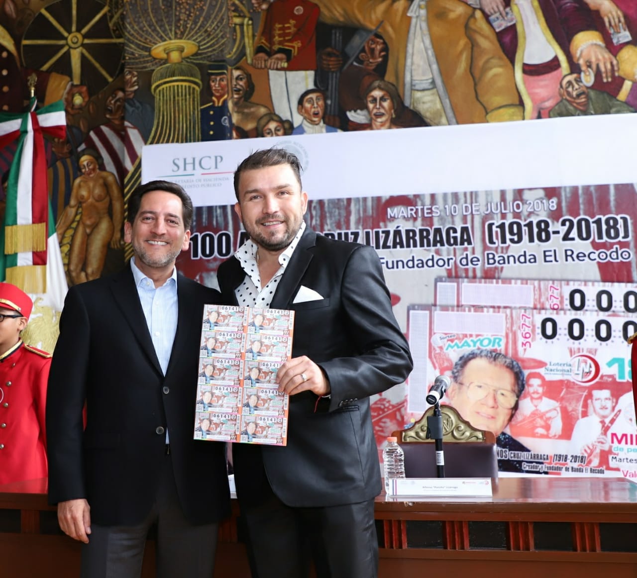 Eugenio Garza Riva Palacio y Poncho Lizárraga posan el billete de Lotería