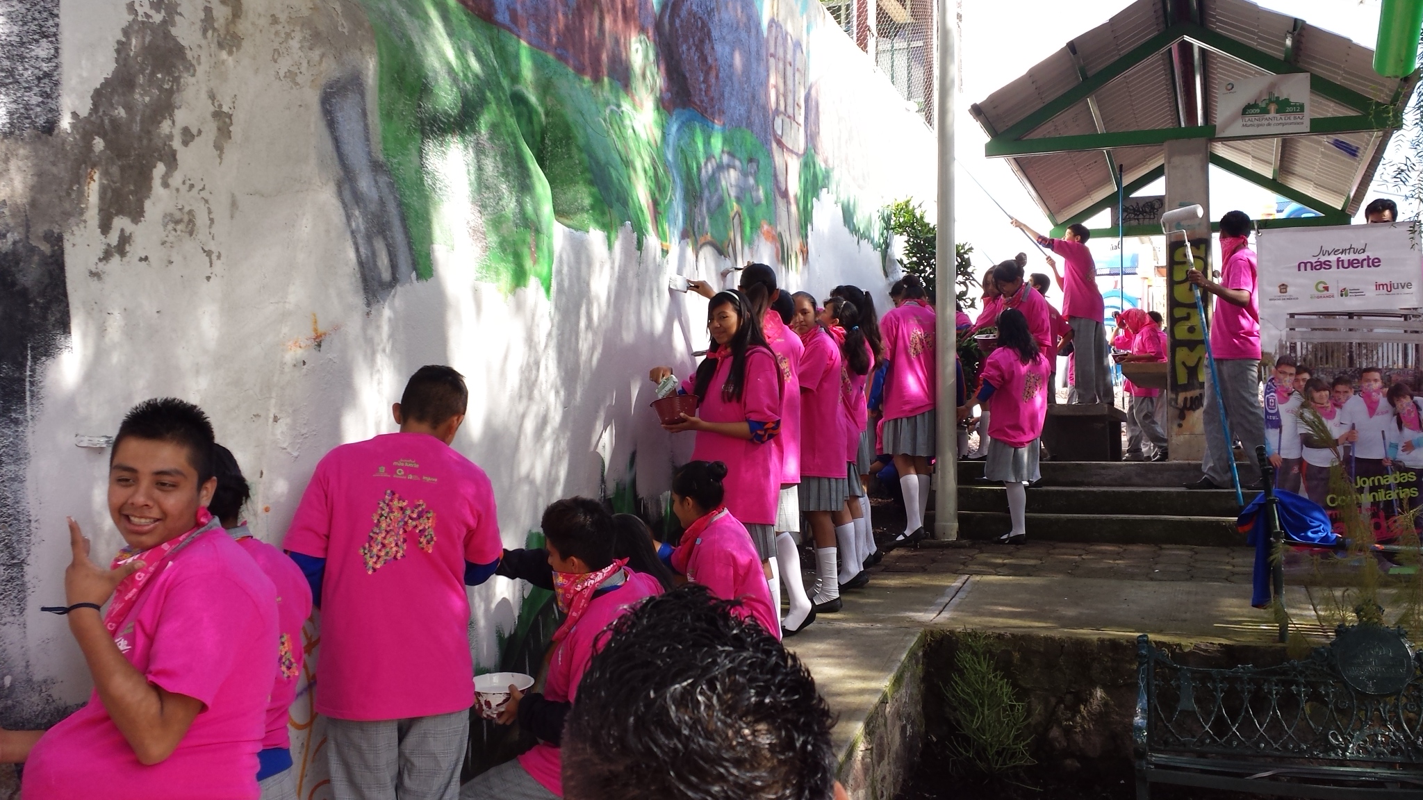 jóvenes pintando un mural en la pared