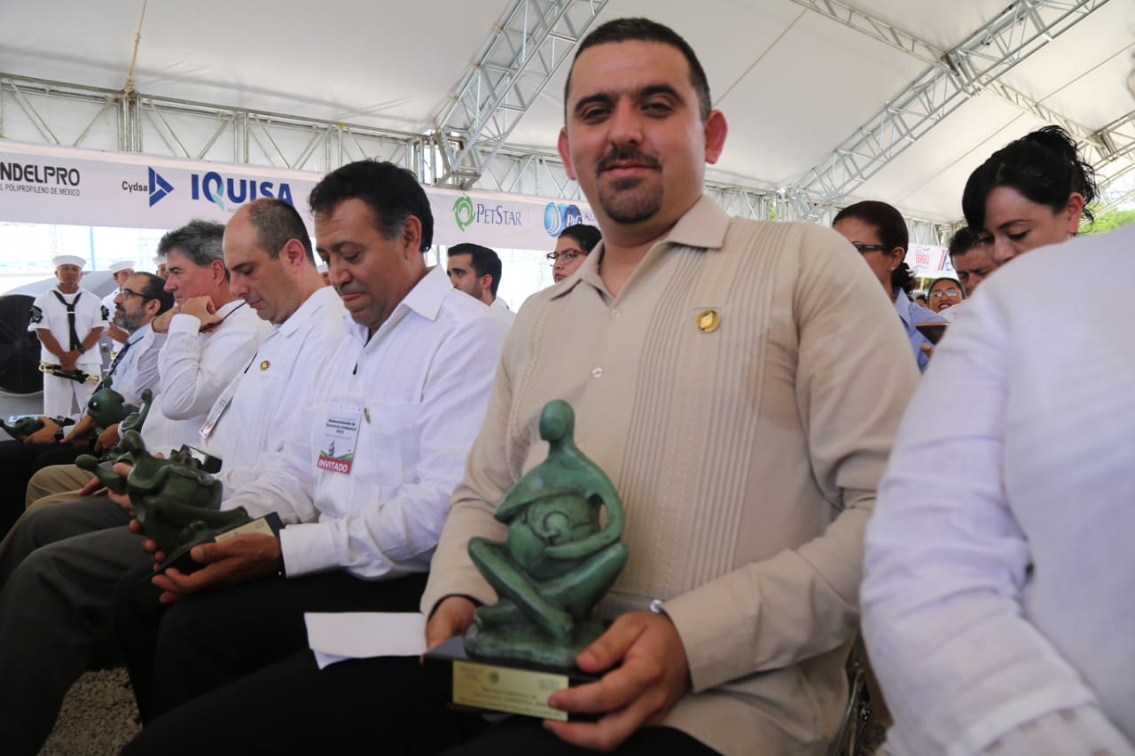 Galardonado muestra premio durante la Entrega de Reconocimientos de Excelencia Ambiental, en Mérida Yucatán.